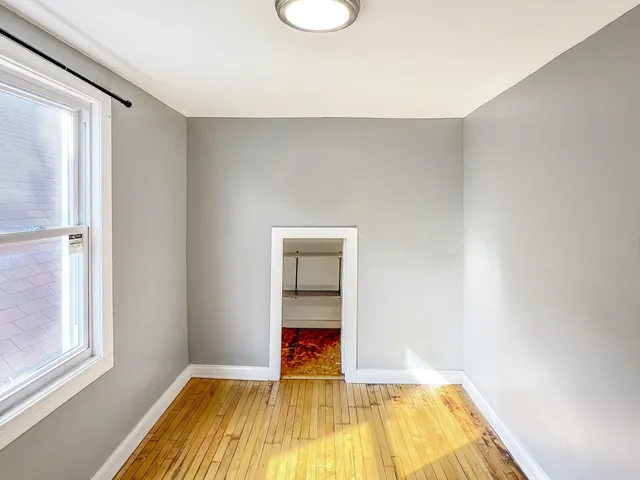 a view of a room with wooden floor and a window