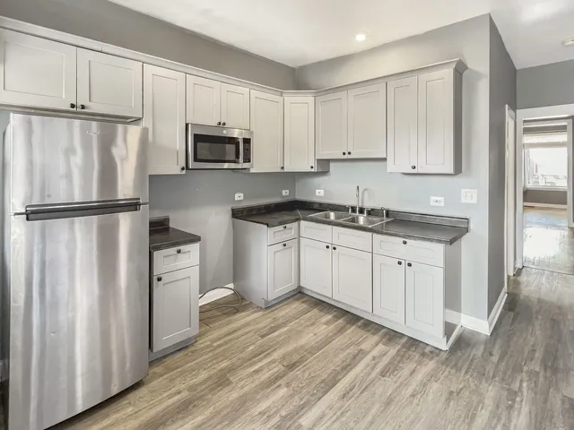 a kitchen with granite countertop white cabinets and white appliances