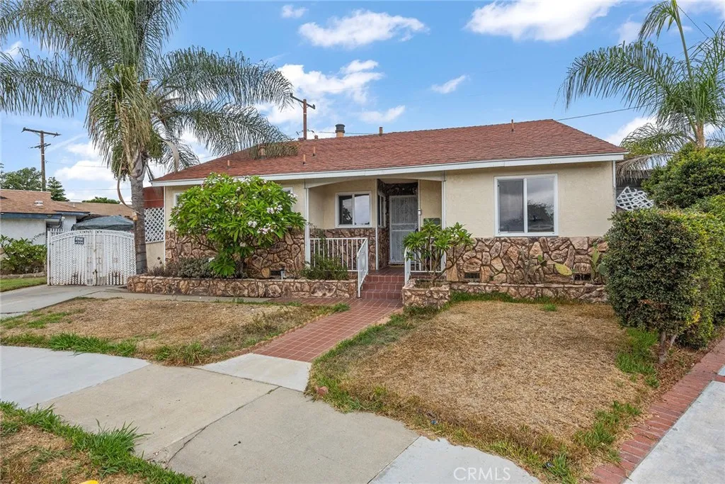 a view of a house with a yard and palm trees
