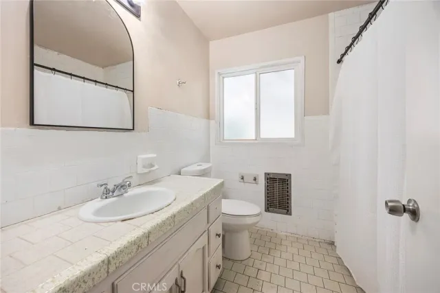 a bathroom with a sink toilet and mirror