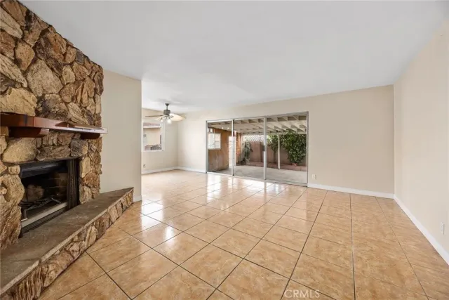 a view of an empty room with glass door and fire place
