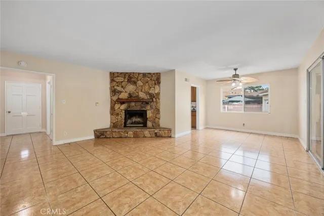 a view of an empty room with a fireplace and a window