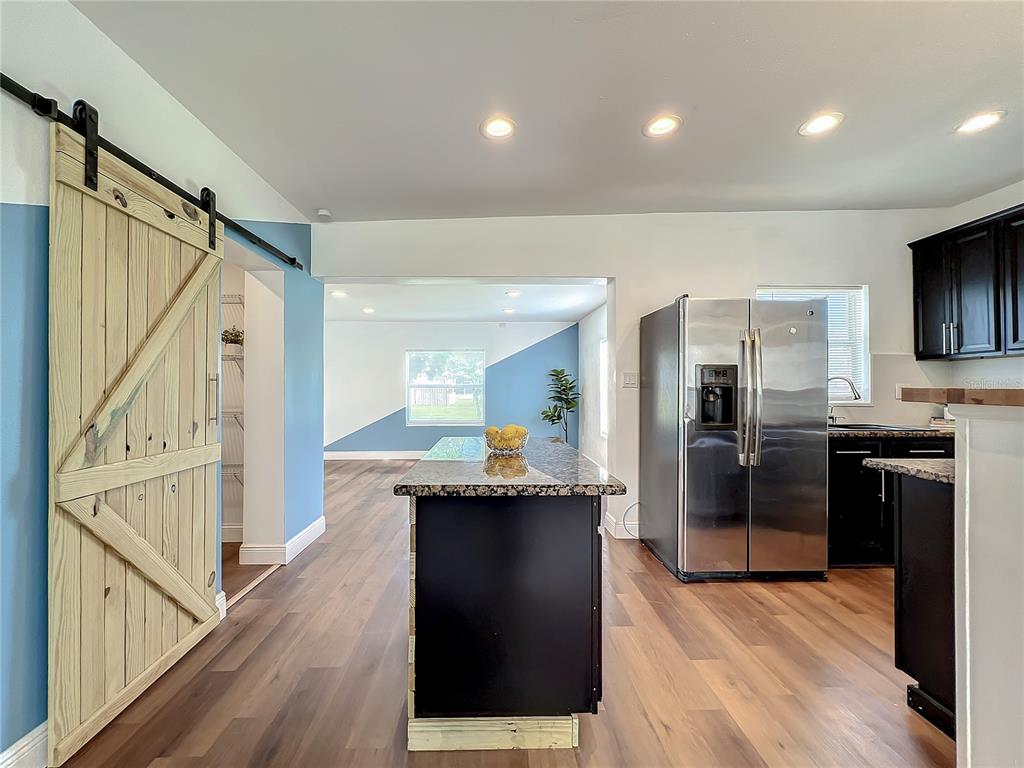 1613 Perkins Road Belle Isle, FL 32809 - Photo 5 of 37 Lively, fresh paint interior with custom-made barn doors left in natural wood color. To the left behind barn door is the walk-through pantry and laundry room.