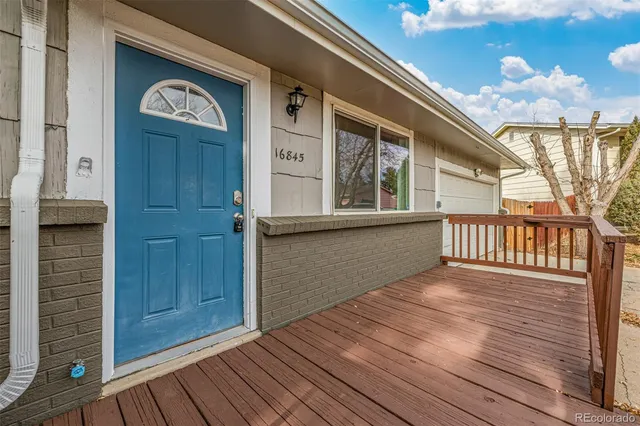 a kitchen with granite countertop white cabinets appliances a sink and a window