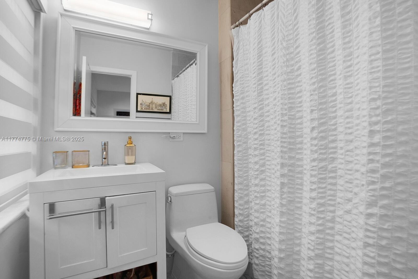 1523 Blue Road Coral Gables, FL 33146 - Photo 12 of 26 a bathroom with a toilet a sink a vanity and mirror