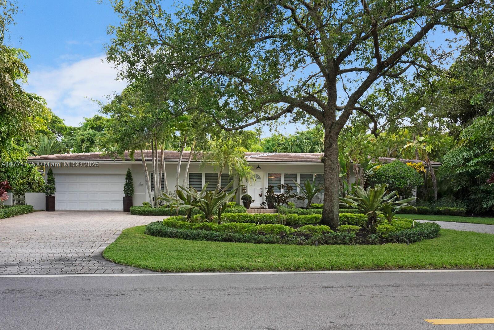 1523 Blue Road Coral Gables, FL 33146 - Photo 2 of 26 a front view of a house with a garden