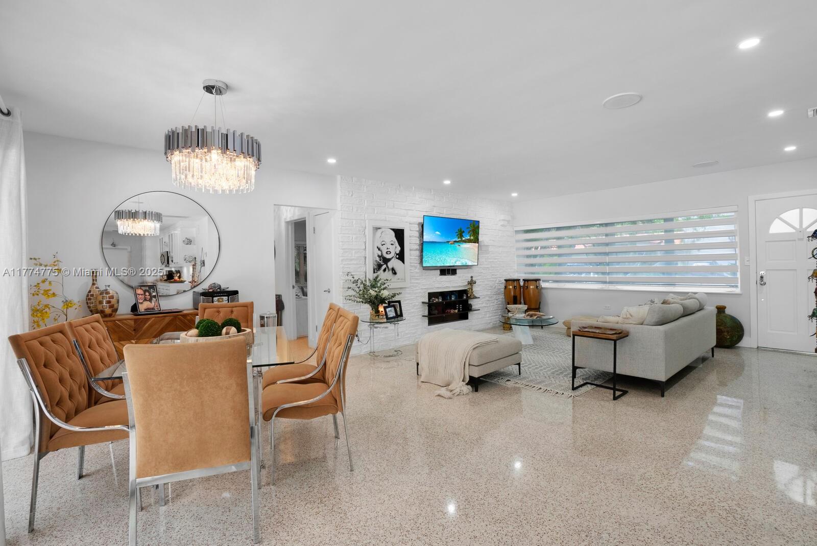 1523 Blue Road Coral Gables, FL 33146 - Photo 6 of 26 a living room with furniture a mirror and a chandelier