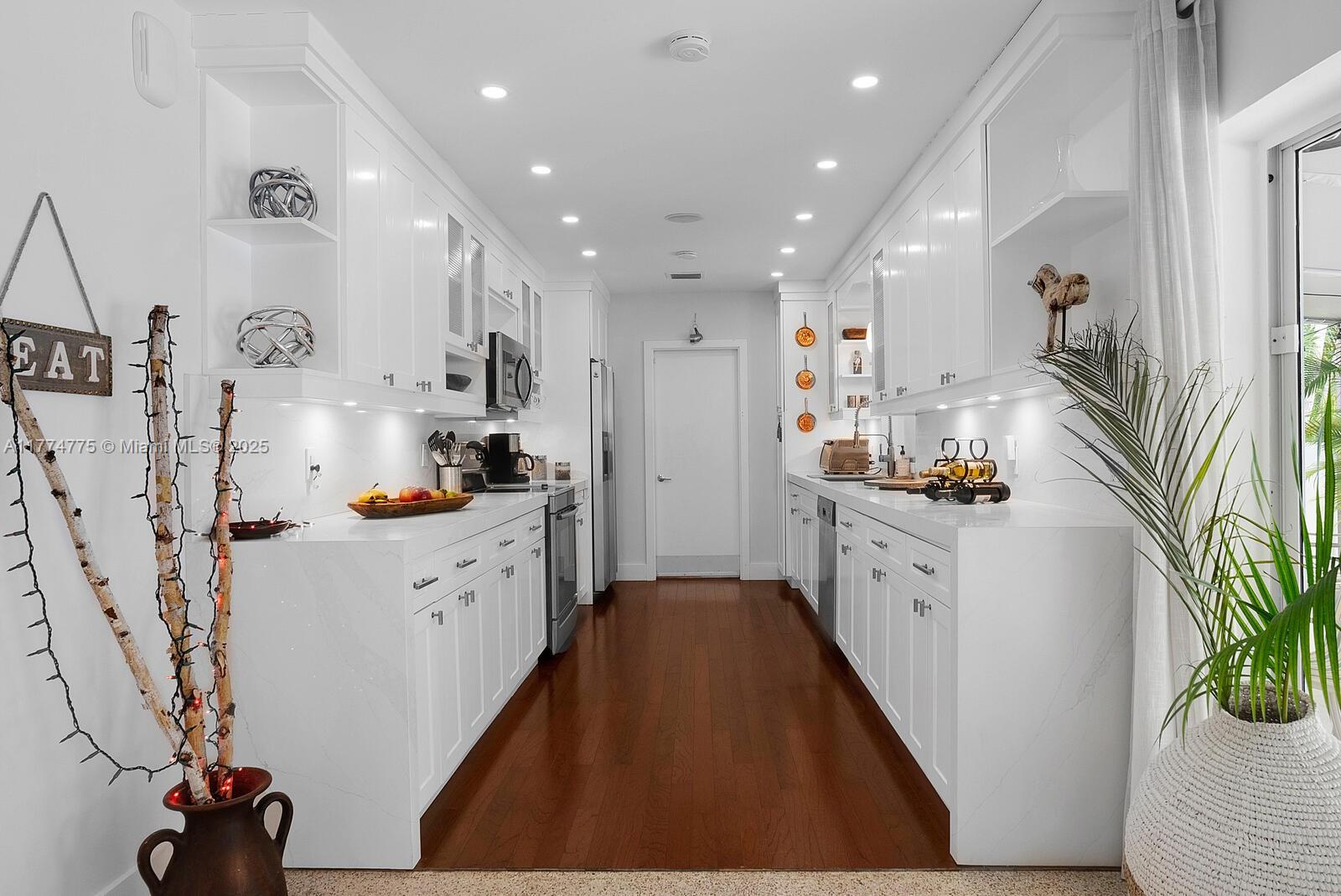 1523 Blue Road Coral Gables, FL 33146 - Photo 9 of 26 a kitchen with white cabinets and appliances