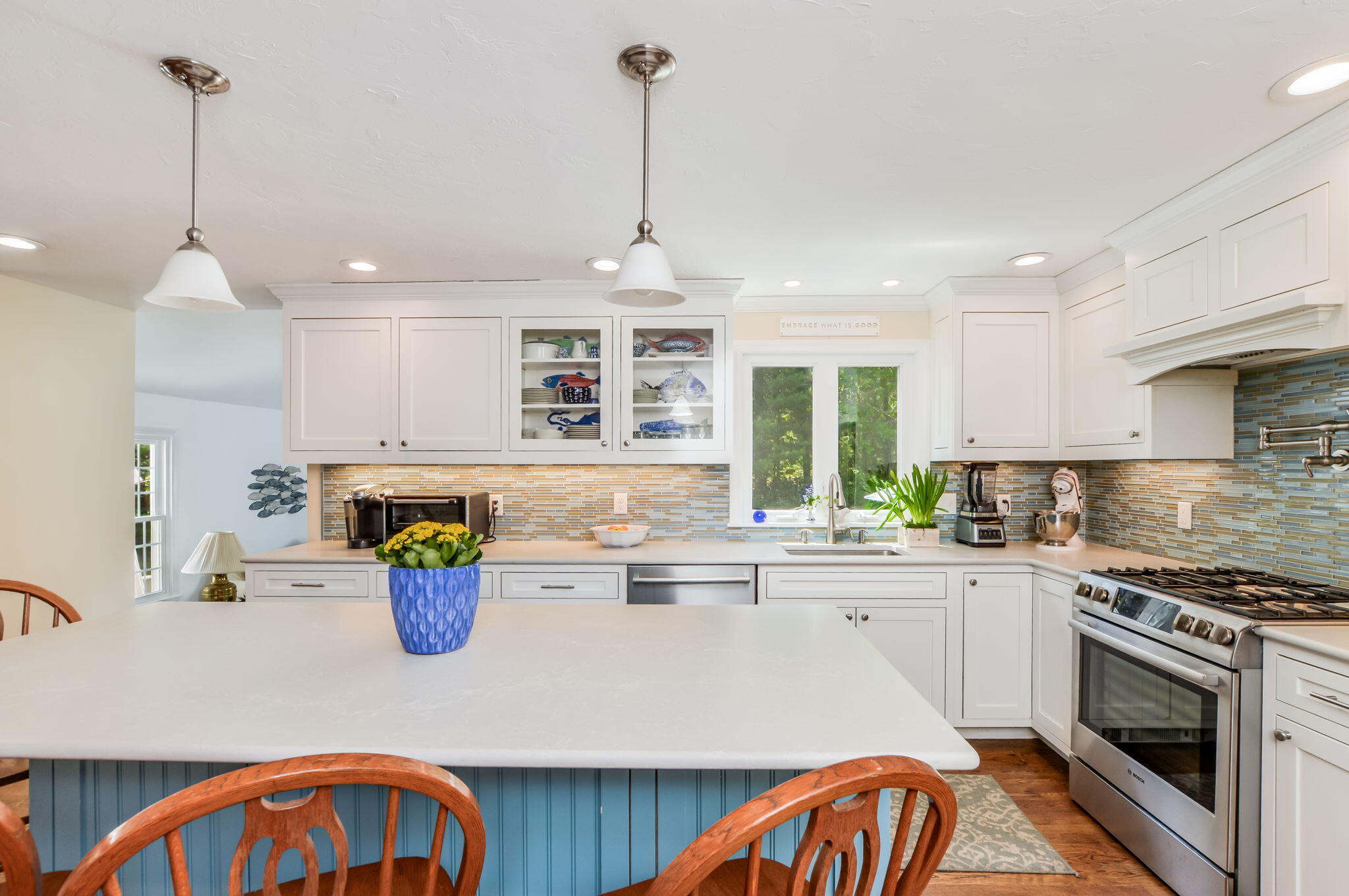 290 Cotuit Bay Drive Cotuit, MA 02635 - Photo 14 of 55 a kitchen with a stove a sink a kitchen island with a dining table and chairs