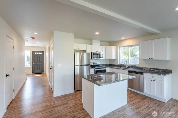a kitchen with stainless steel appliances kitchen island wooden cabinets and granite counter tops