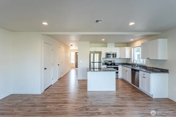 a kitchen with stainless steel appliances granite countertop a sink stove and refrigerator