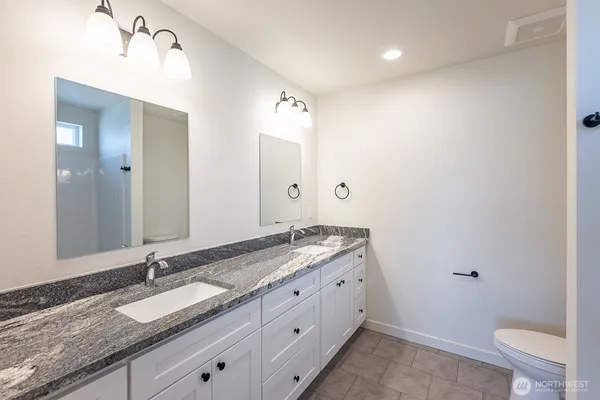 a bathroom with a granite countertop tub sink and mirror