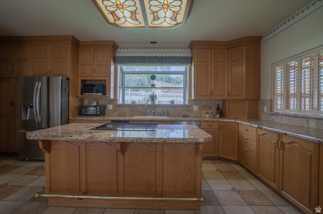 5302 South Birch Pt Road Murray, UT 84117 - Photo 10 of 29 Expansive kitchen featuring an island with cooktop, granite countertops, wood cabinetry, stainless steel refrigerator, and tiled flooring