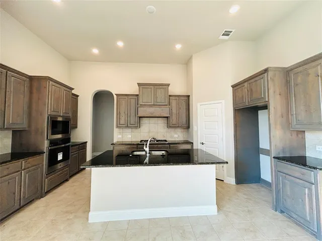 a kitchen with stainless steel appliances a refrigerator sink and stove