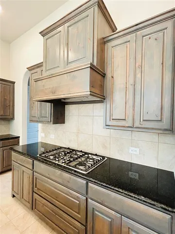 a kitchen with granite countertop cabinets and black appliances