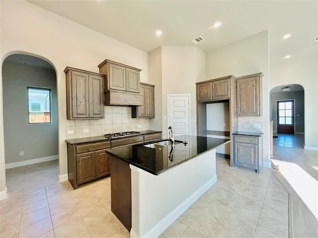 a kitchen with stainless steel appliances granite countertop a sink and refrigerator