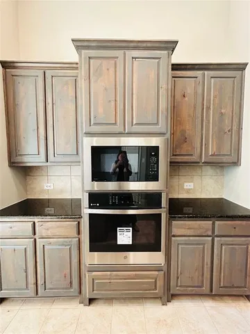 a kitchen with granite countertop white cabinets and stainless steel appliances