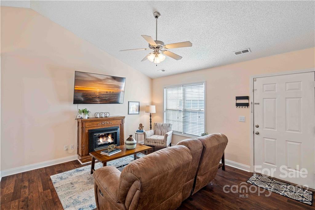 321 Dexter Place Monroe, NC 28110 - Photo 3 of 17 a living room with furniture a fireplace and a flat screen tv