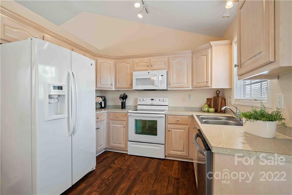 321 Dexter Place Monroe, NC 28110 - Photo 6 of 17 a kitchen with stainless steel appliances white cabinets a stove a sink dishwasher and a refrigerator with wooden floor