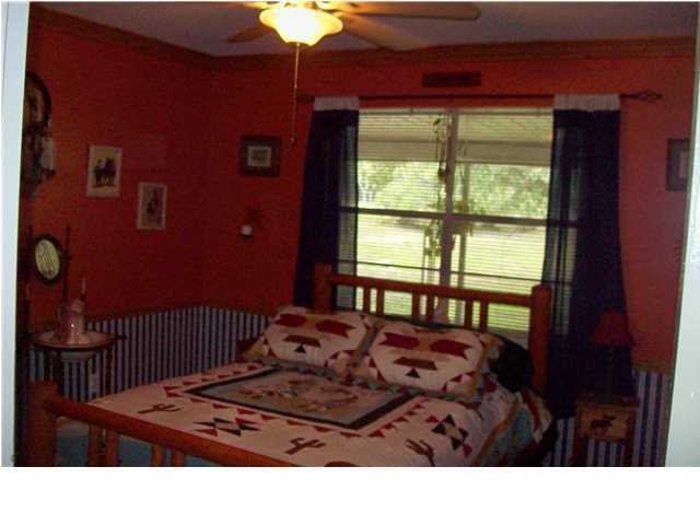 6023 Dairy Road Baker, FL 32531 - Photo 11 of 29 a black leather chair in front of a room with a bed and a window