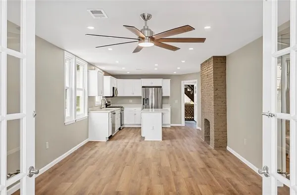 a view of kitchen with center island wooden floor and stainless steel appliances