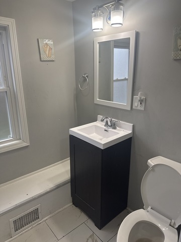 15818 St Louis Avenue Markham, IL 60428 - Photo 14 of 17 a bathroom with a sink vanity mirror and toilet