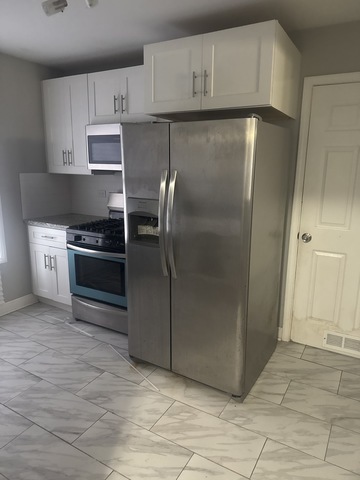 15818 St Louis Avenue Markham, IL 60428 - Photo 6 of 17 a kitchen with white cabinets and stainless steel appliances