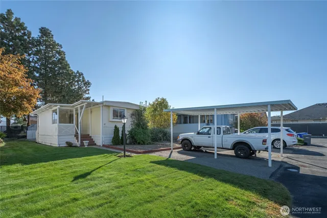 a front view of house with yard and car parked