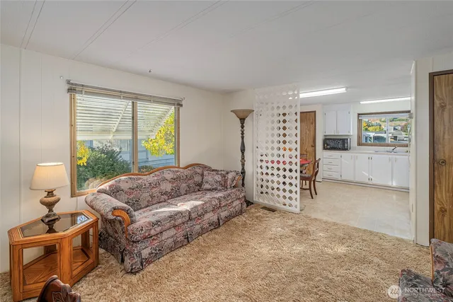a living room with a bed furniture and next to a window