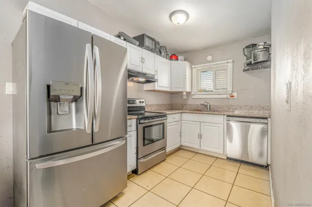 a kitchen with granite countertop a refrigerator and a sink