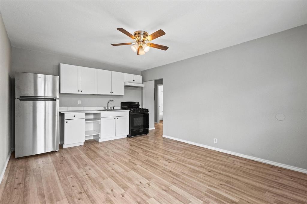 701 West Hull Street, Unit 1012 Denison, TX 75020 - Photo 8 of 22 a kitchen with a refrigerator and white cabinets