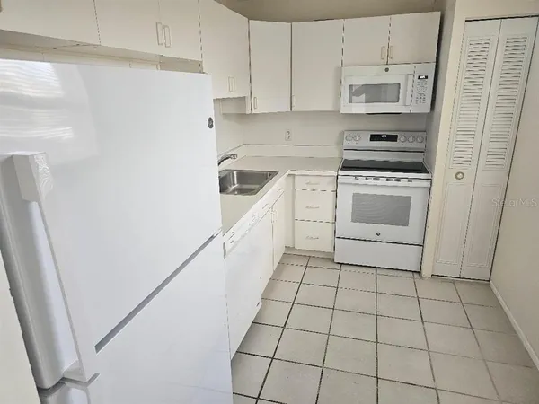 a kitchen with a stove a sink and a refrigerator