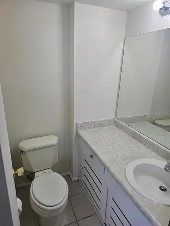 a bathroom with a granite countertop toilet and a sink