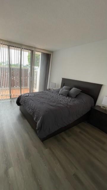 225 South Beach Road, Unit 105 Tequesta, FL 33469 - Photo 11 of 16 a bedroom with a bed and wooden floor