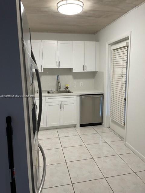 225 South Beach Road, Unit 105 Tequesta, FL 33469 - Photo 5 of 16 a kitchen with stainless steel appliances a refrigerator sink and cabinets
