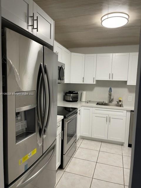 225 South Beach Road, Unit 105 Tequesta, FL 33469 - Photo 6 of 16 a kitchen with a refrigerator sink and cabinets