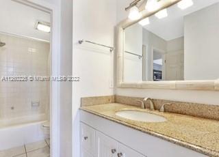 225 South Beach Road, Unit 105 Tequesta, FL 33469 - Photo 10 of 16 a bathroom with a granite countertop sink and a mirror
