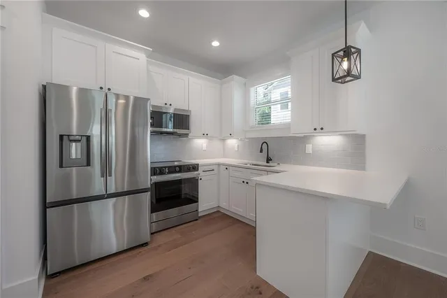 a kitchen with granite countertop a refrigerator stove and sink