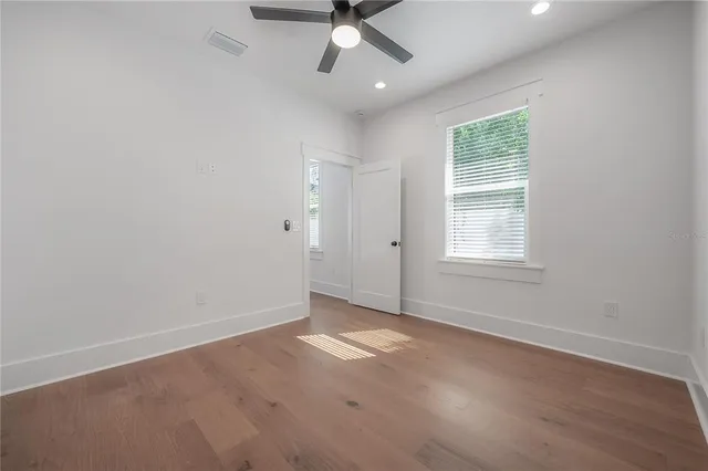 an empty room with a window and a ceiling fan