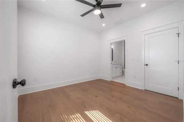 an empty room with a ceiling fan and window