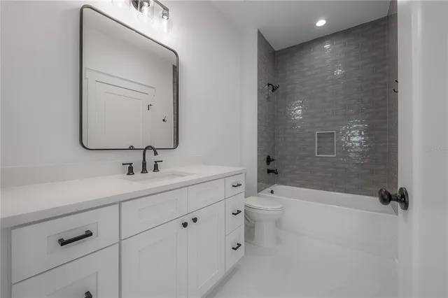 a bathroom with a toilet a sink a mirror a shower and vanity