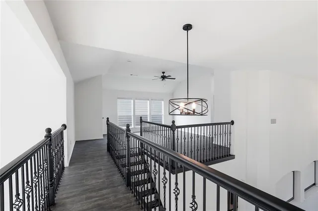 a view of a hallway to room with wooden floor