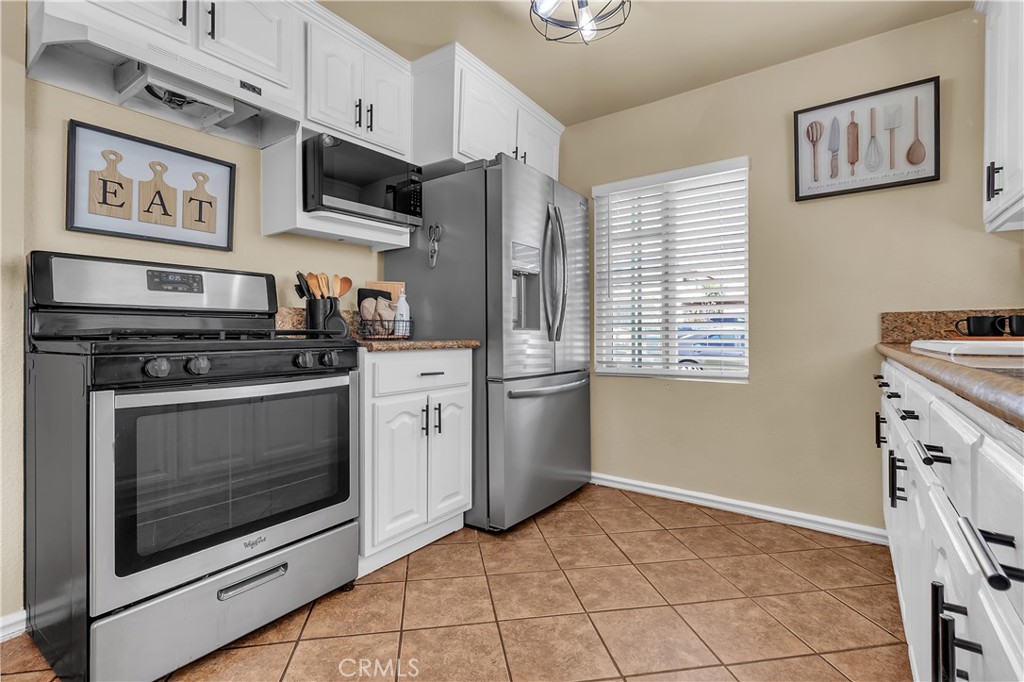 1414 West Shorb Street Alhambra, CA 91803 - Photo 9 of 33 a kitchen with stainless steel appliances a stove a microwave and cabinets