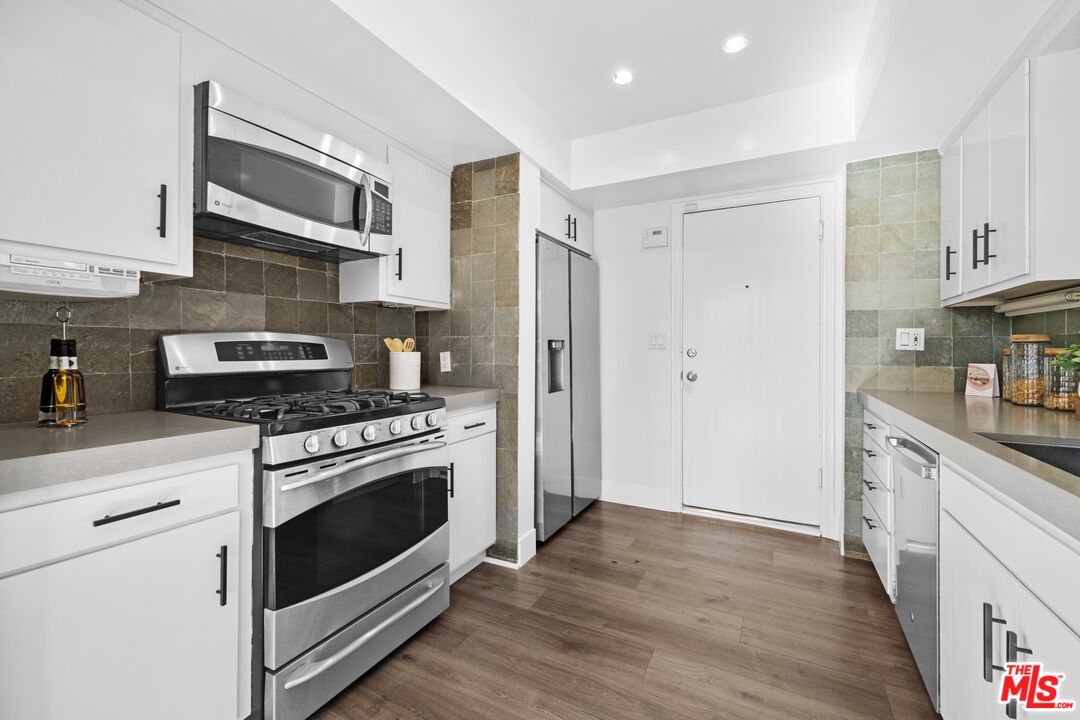 3366 Troy Drive Los Angeles, CA 90068 - Photo 7 of 24 a kitchen with stainless steel appliances white cabinets a stove a sink and a refrigerator