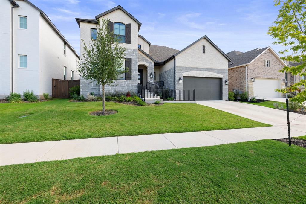 1008 Willie Rnch Way Leander, TX 78641 - Photo 2 of 40 French country inspired facade featuring stone siding, a front lawn, driveway, a garage, and brick siding