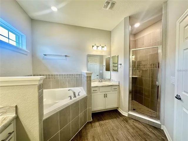 a bathroom with a bathtub shower and sink