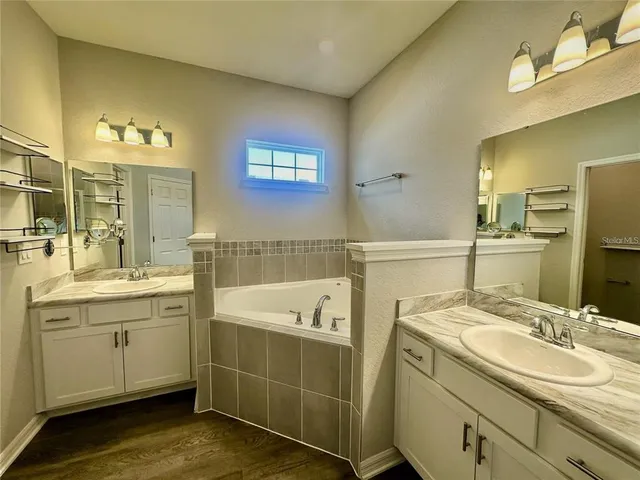 a bathroom with a tub sink and mirror