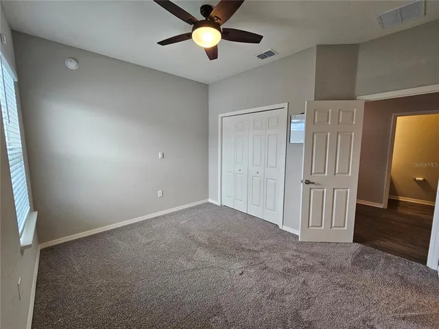 an empty room with closet and windows