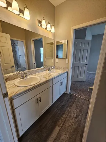a bathroom with a sink double vanity granite and a mirror