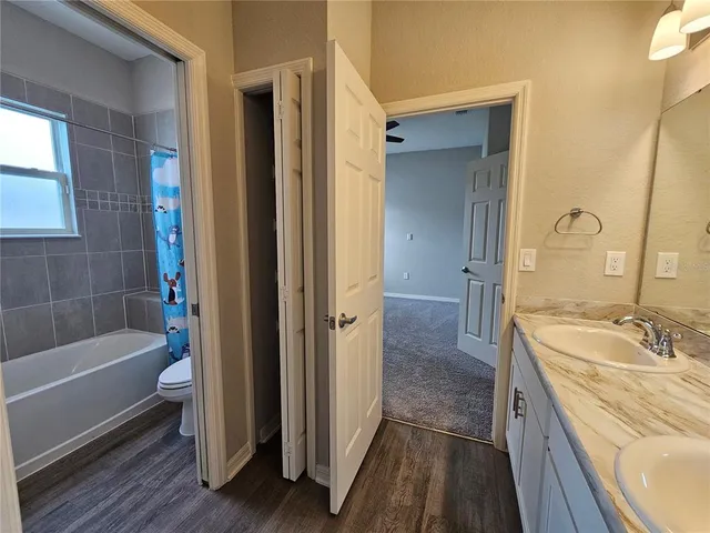 a bathroom with a tub a sink and a large mirror